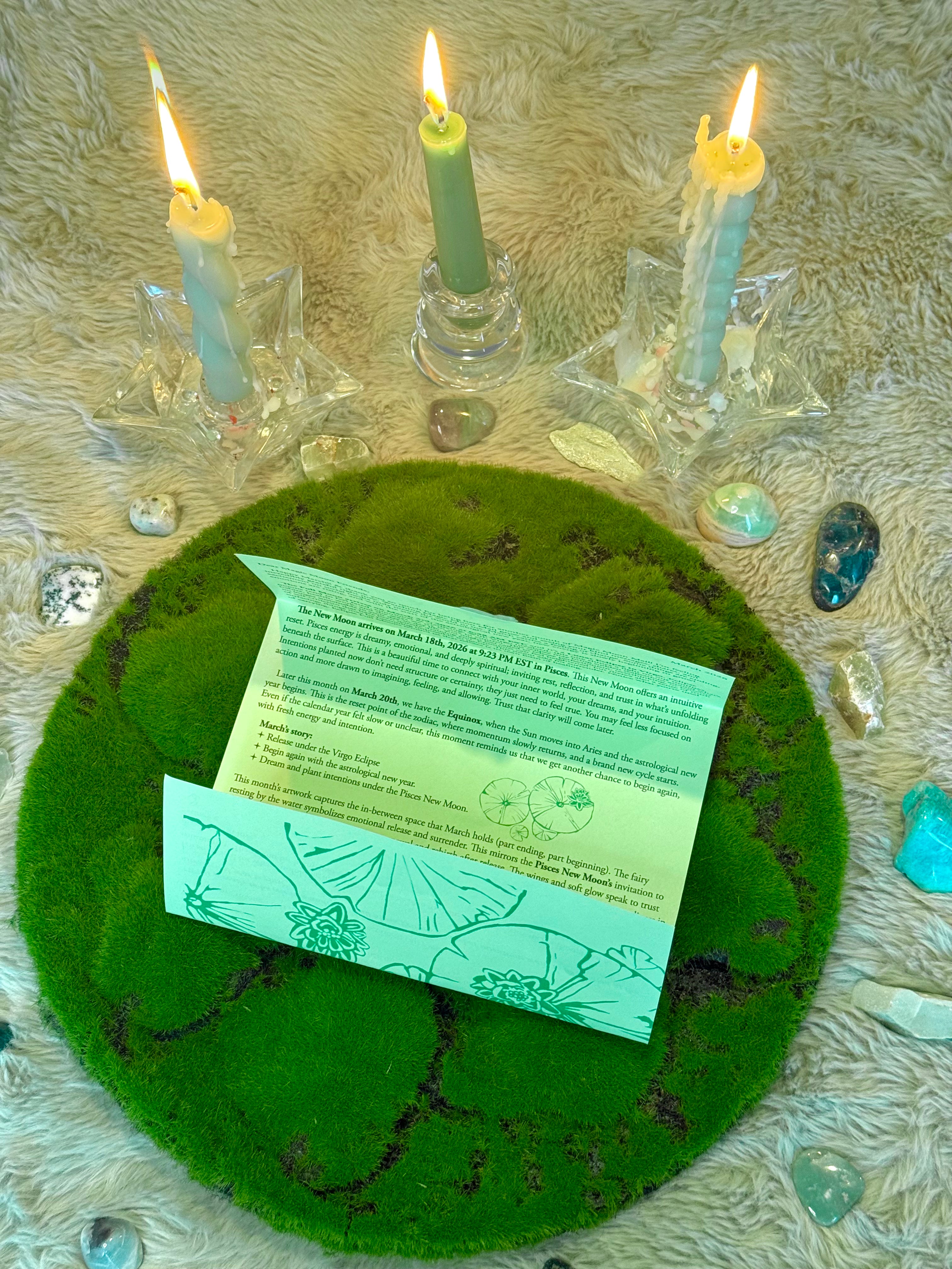 Candles around a green felt circle with a card on top, on a textured surface.