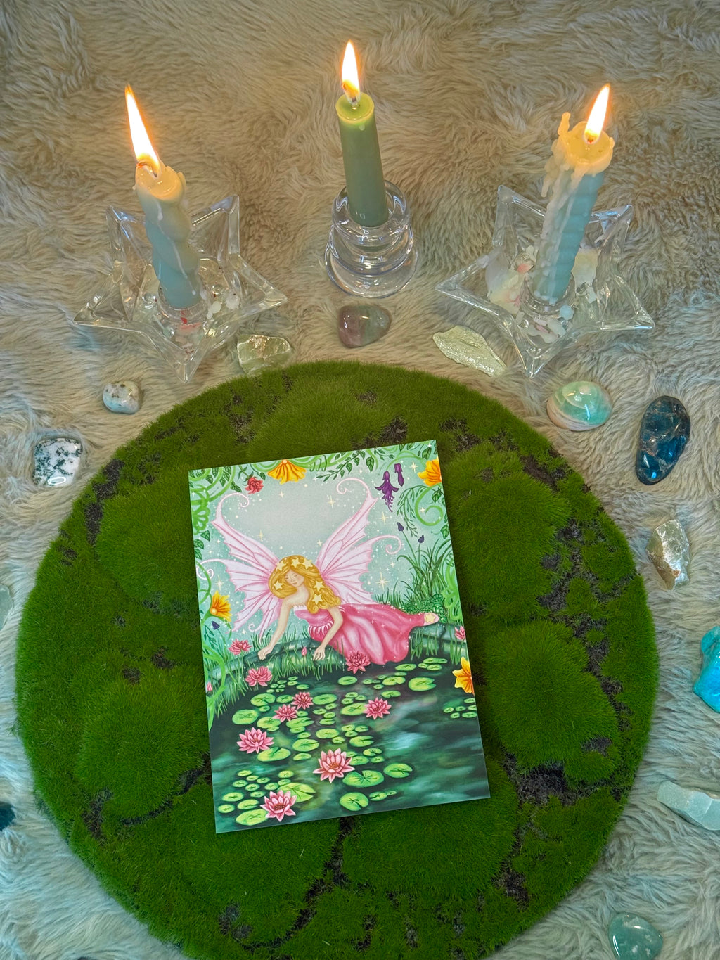 Fairy card on a green felt circle with candles and crystals