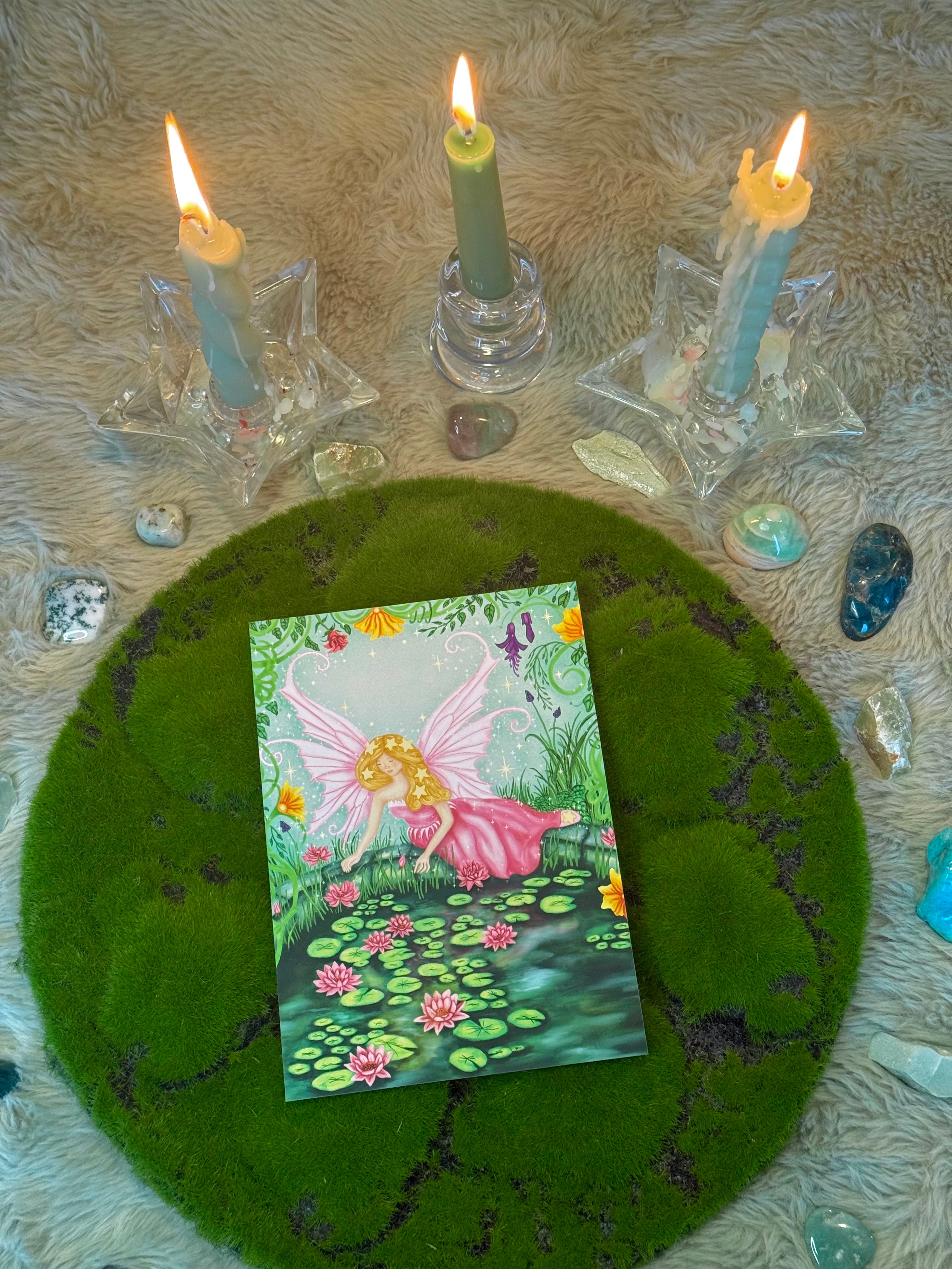 Fairy card on a green felt circle with candles and crystals
